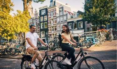 Couple cycling on bikes in Amsterdam