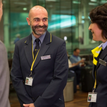 Eurostar Employees smiling at each other in the departure lounge.