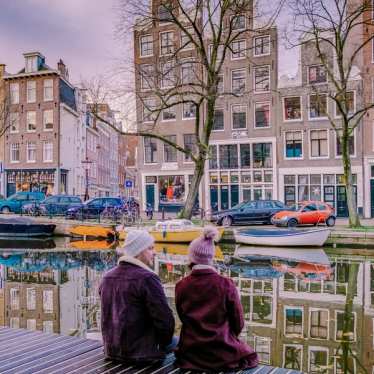Amsterdam dutch canals , couple visit dutch canals during city trip in Amsterdam, men and woman on city trip in Amsterdam Netherlands