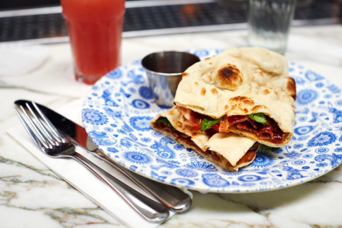A bacon naan roll on a plate at Dishoom.
