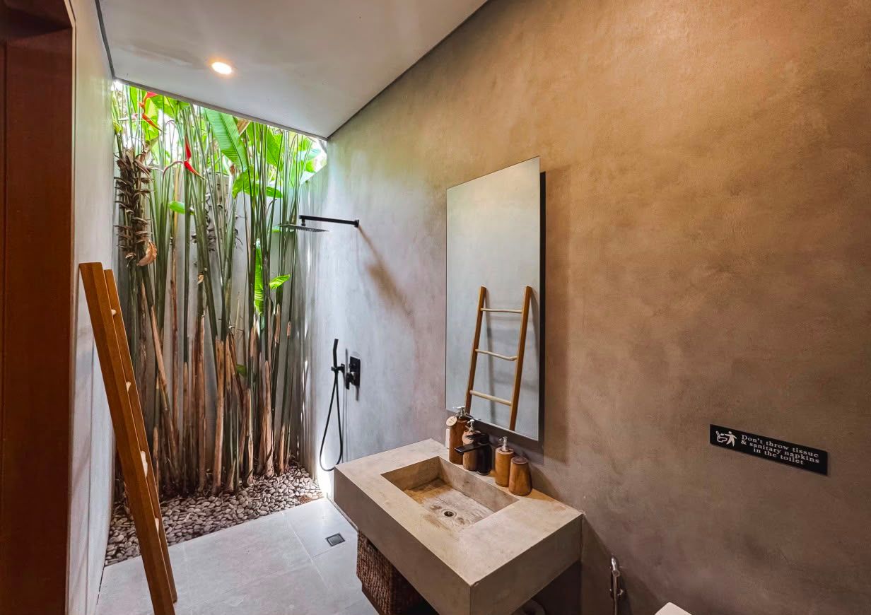 Polished-concrete bathroom with rain shower and planted light well