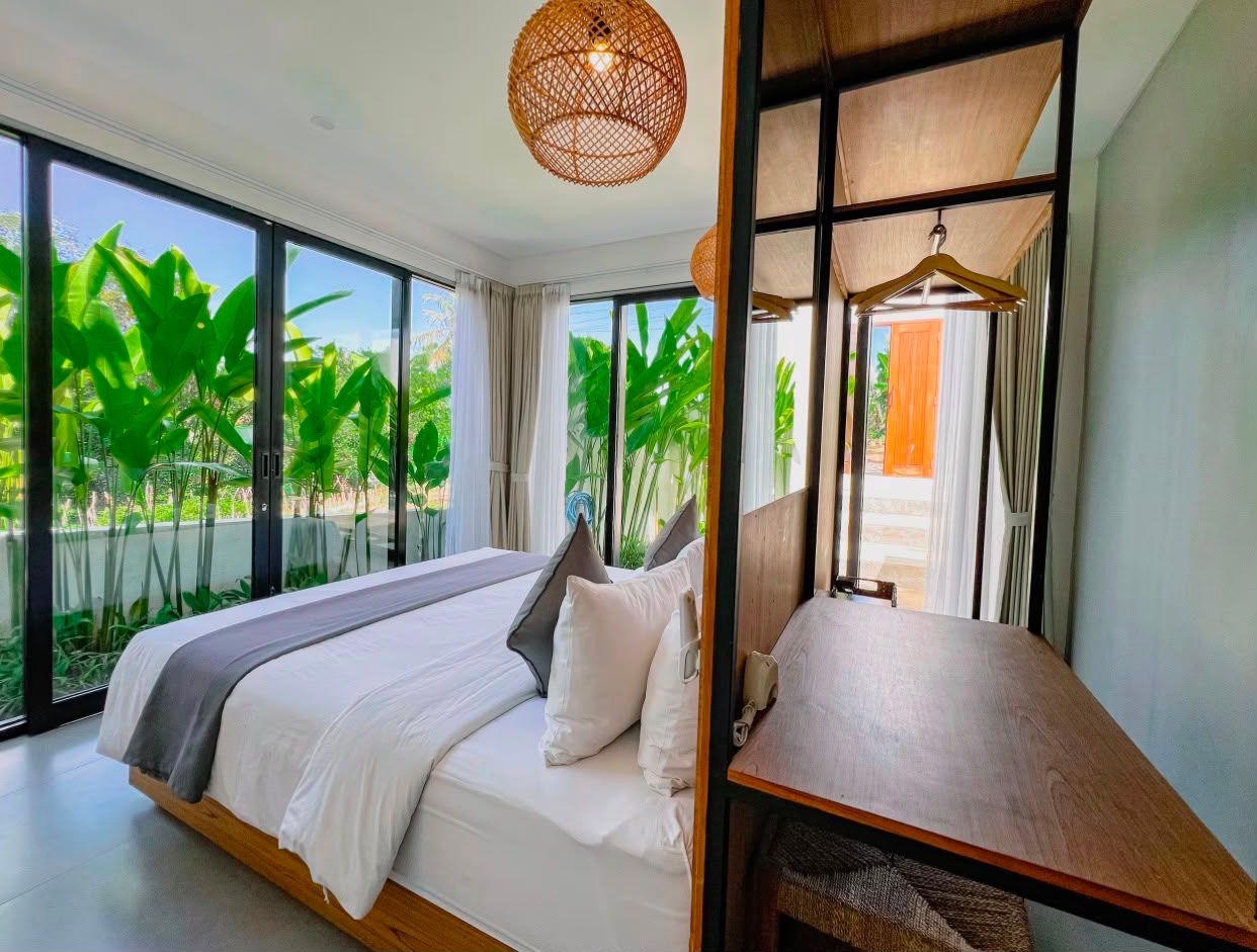 Bedroom with rattan pendant lights and garden outlook