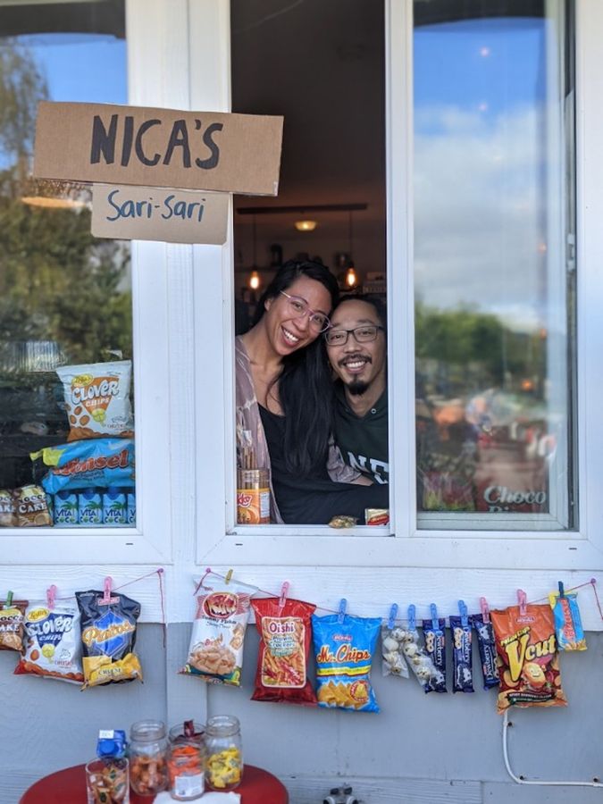 A woman and a man standing behind the window and smiling together