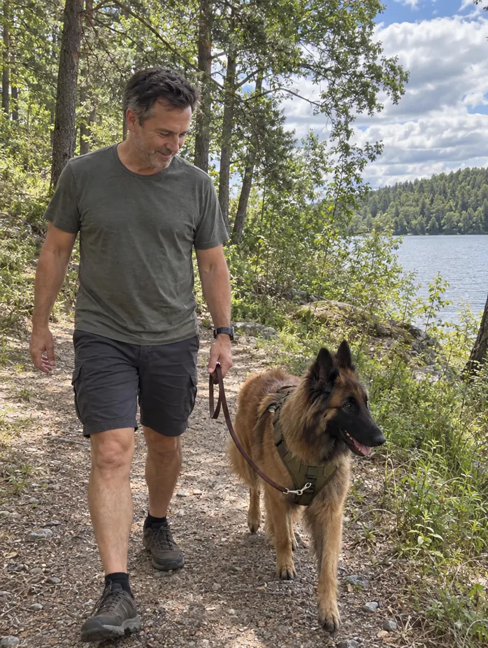 Jonas walking his Belgian Shepherd Sigge in a green Tactical Harness on a forest trail