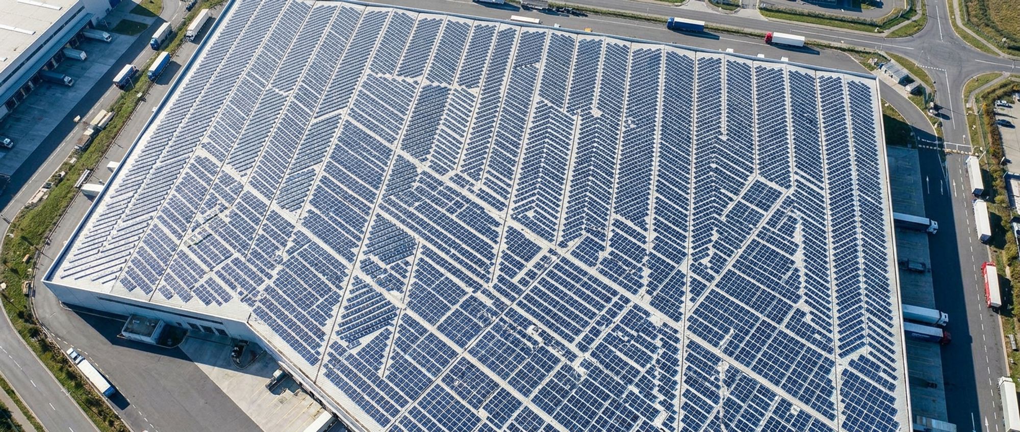 Aerial view of a warehouse roof covered in solar panels