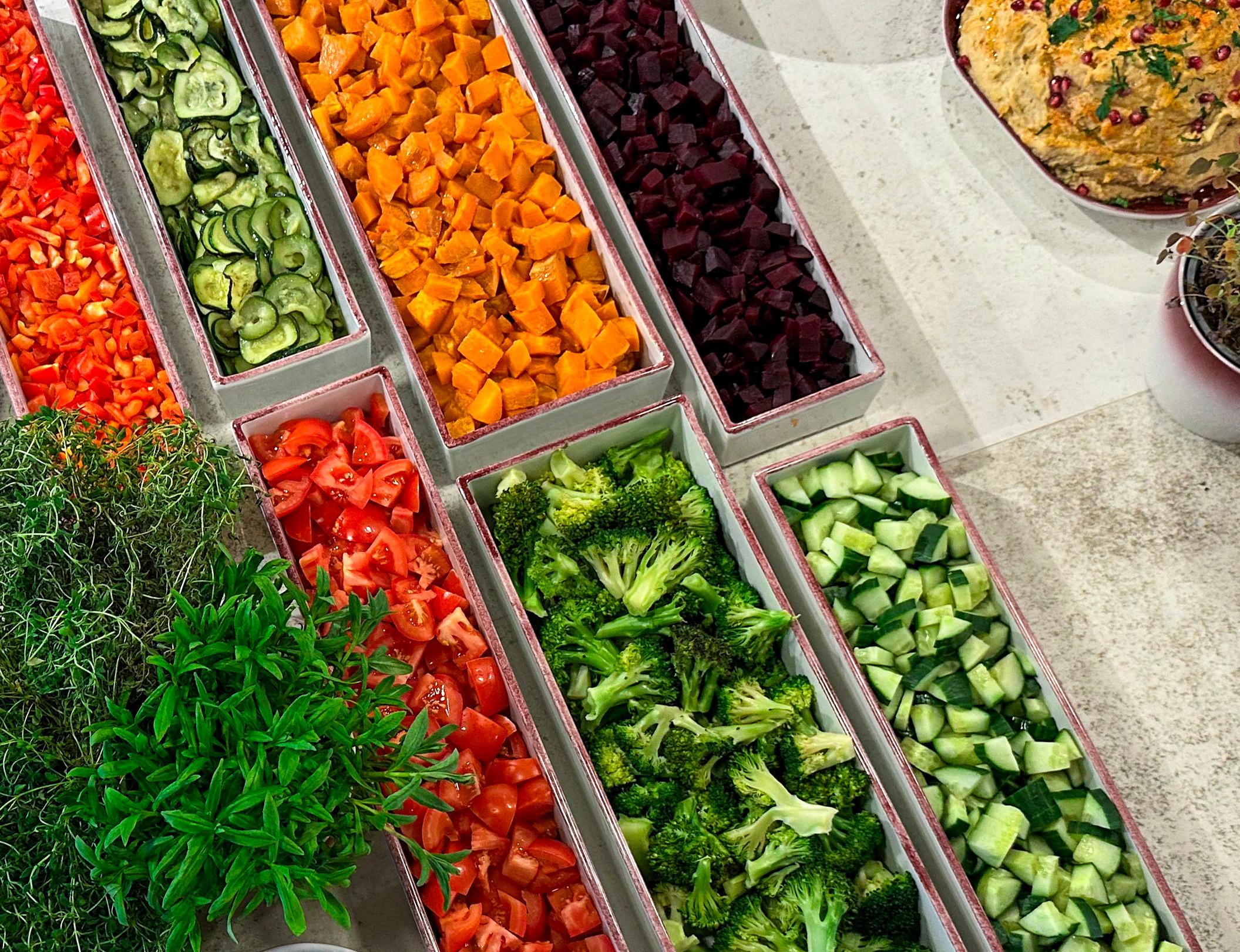 Hånd forsyner seg av varmrett på tallerken fra buffet i kantine
