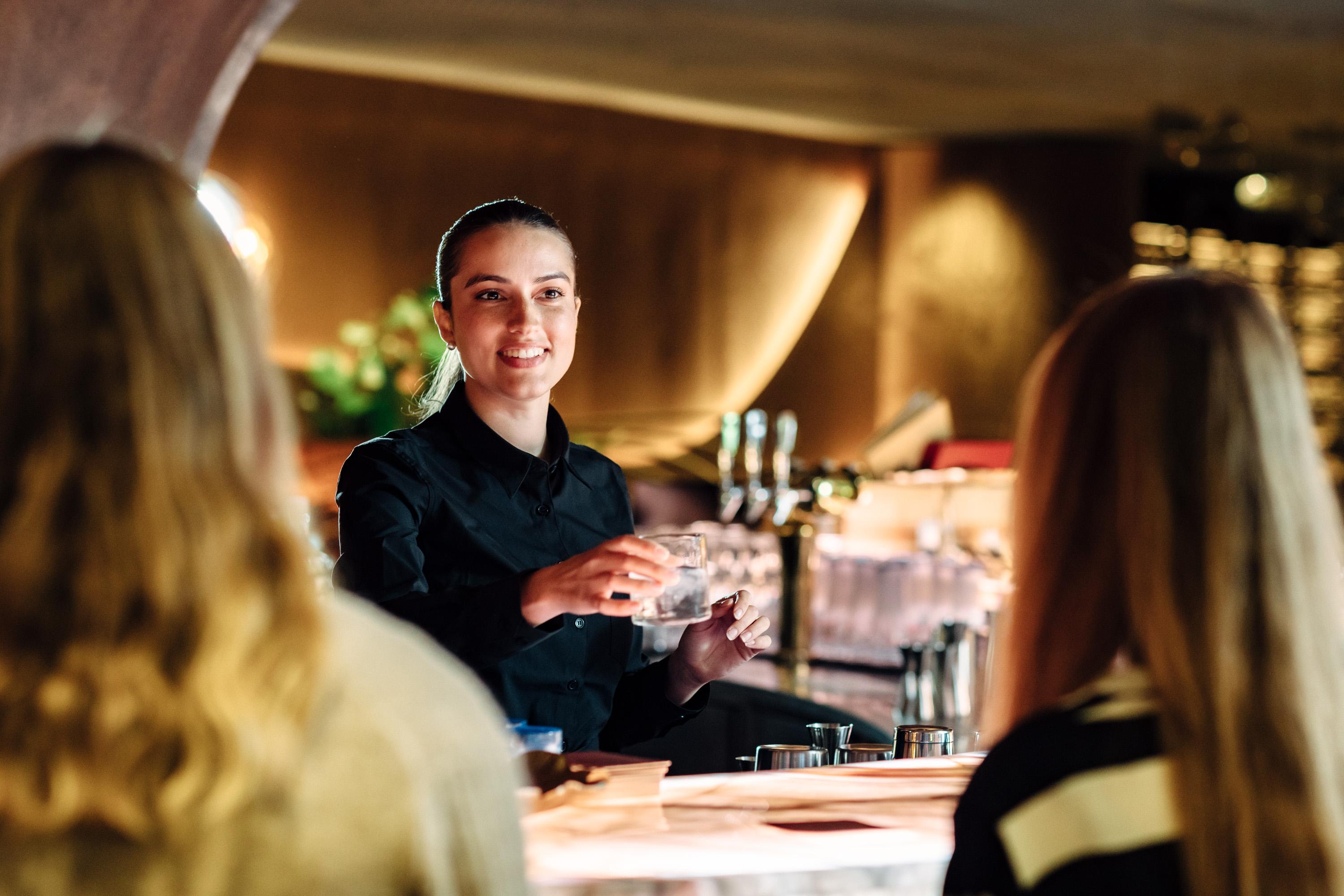 Bartender serverer kunder i baren
