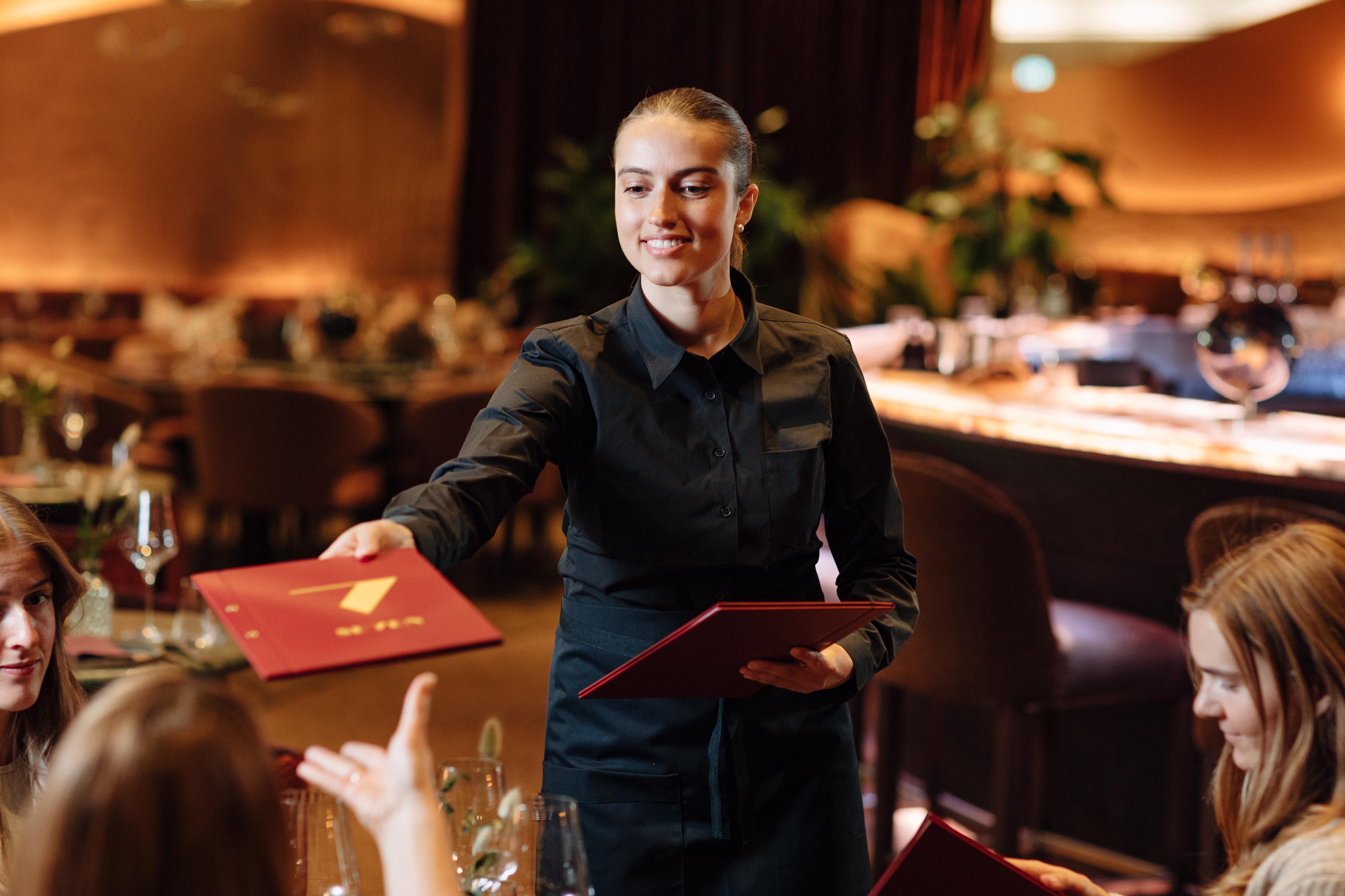 Servitør som deler ut menyer