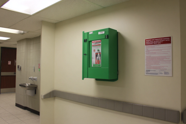 A first aid station and automated external defibrillator in a campus corridor.