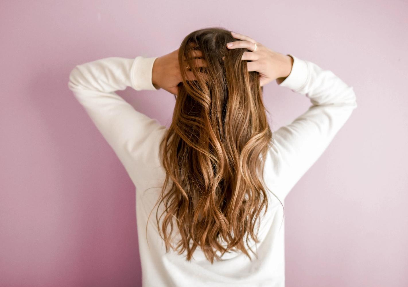Kvinne med hair extensions tar seg i håret