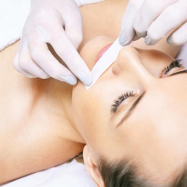 Hårfjerning på overlepper på kvinne som ligger på behandlingsbenk