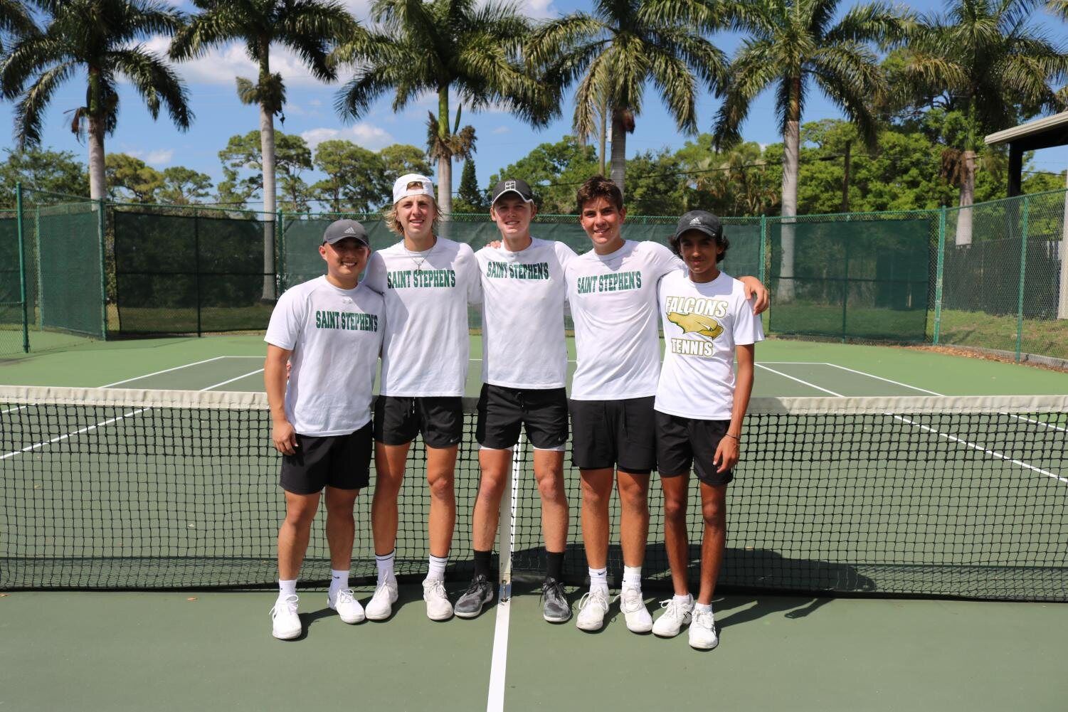 The boys' tennis team poses together at the net on the Saint Stephen's courts.