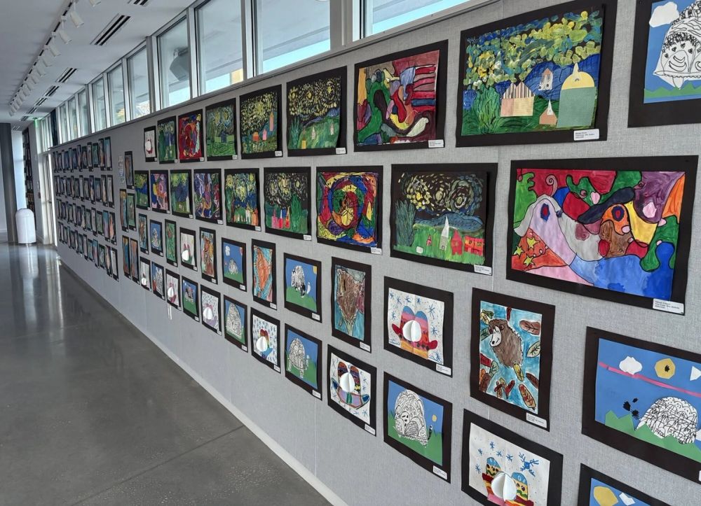 A long gallery wall displays framed student artwork at Saint Stephen's.