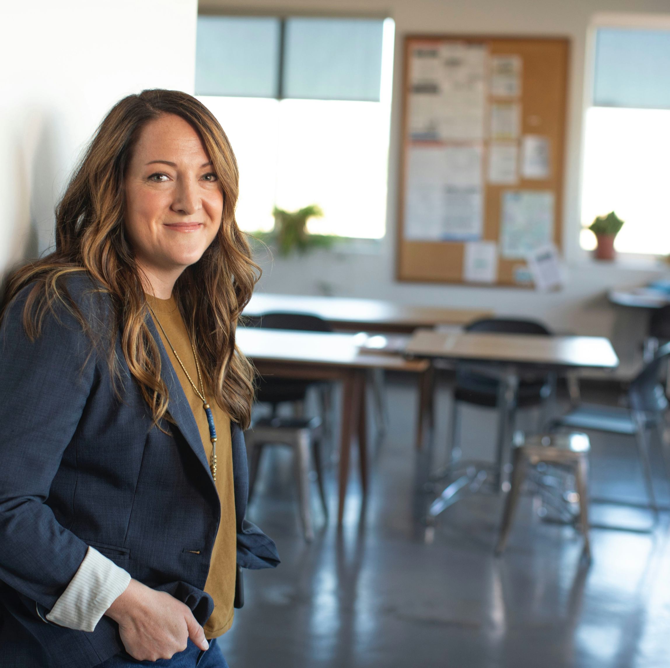 Woman standing against wall in business attire