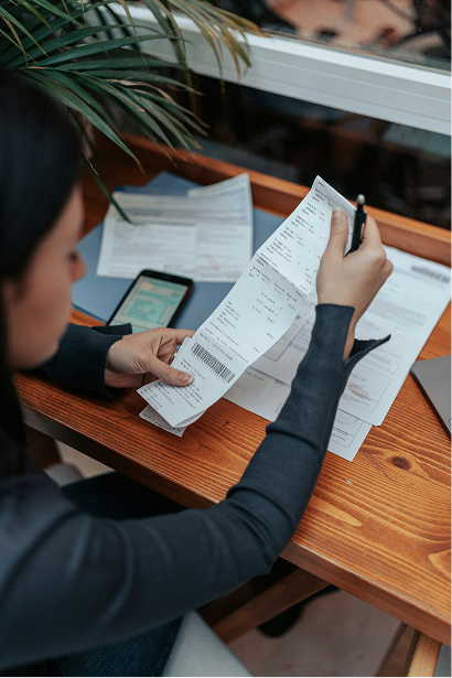 A woman overseeing a stack of bills