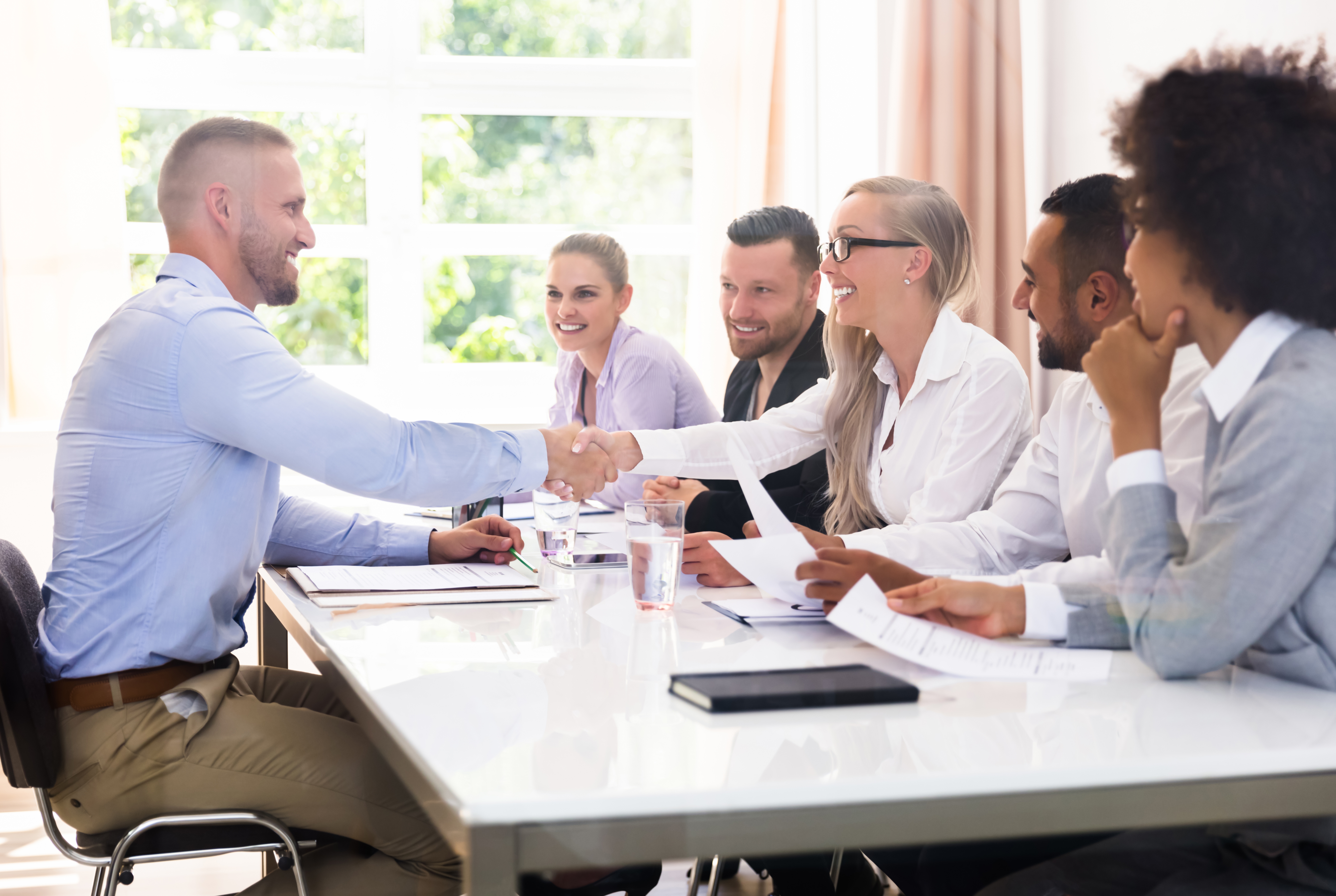 A team meeting, with people smiling and shaking hands with the rep.