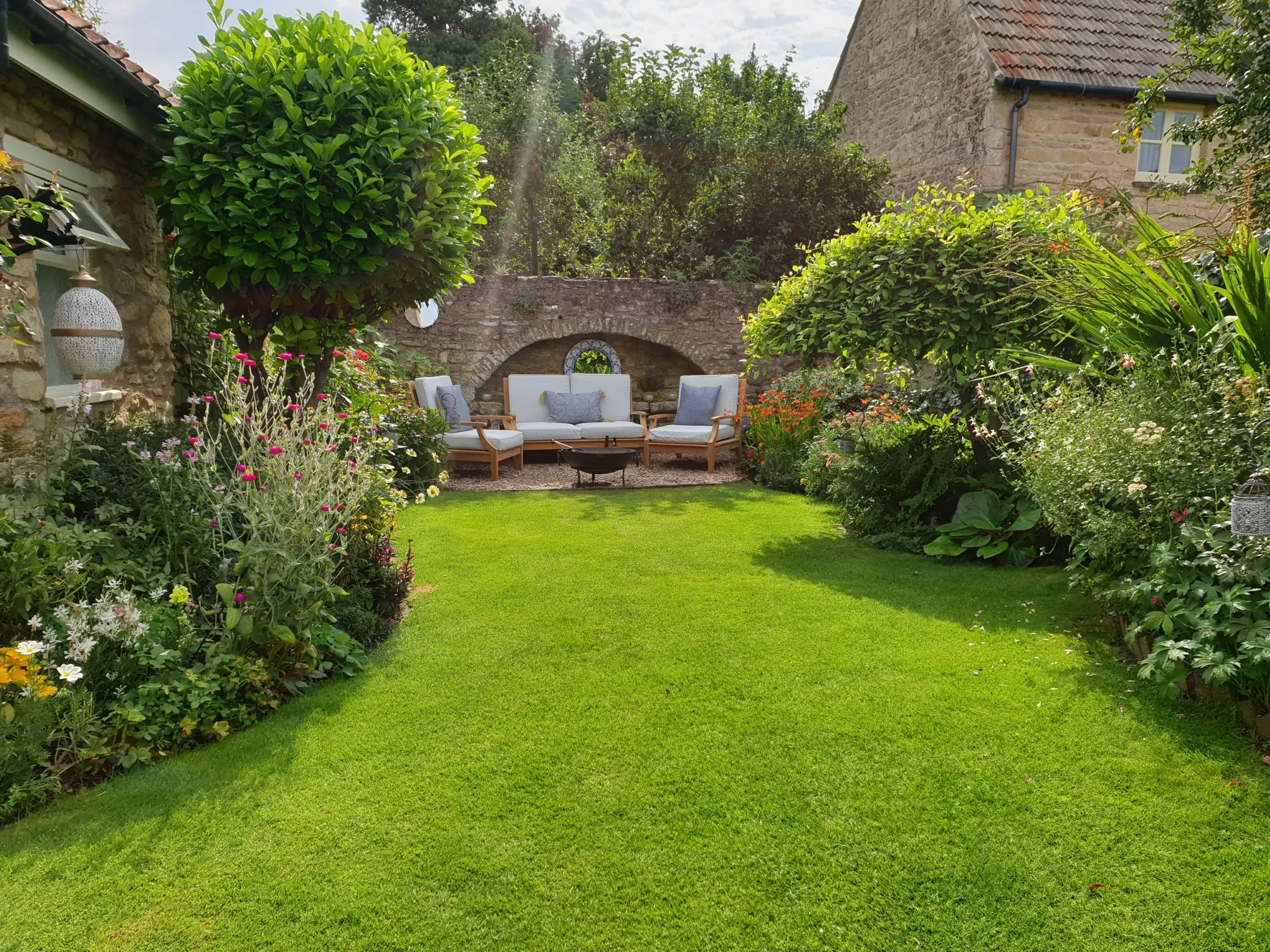 Green Lawn surrounded by plants and flowers