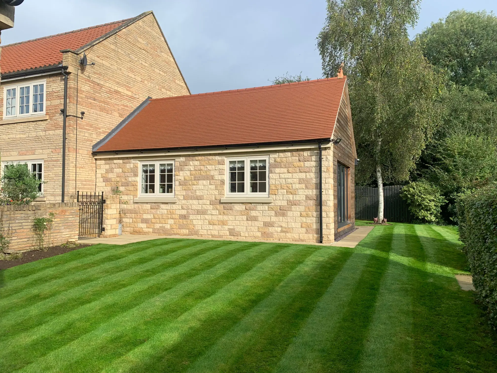 House with thick lush grass with mowed stripes