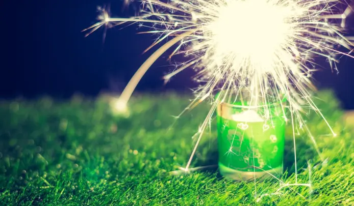 Sparkler lit on grass, showing lawn-friendly celebration setup for a safe Bonfire Night.