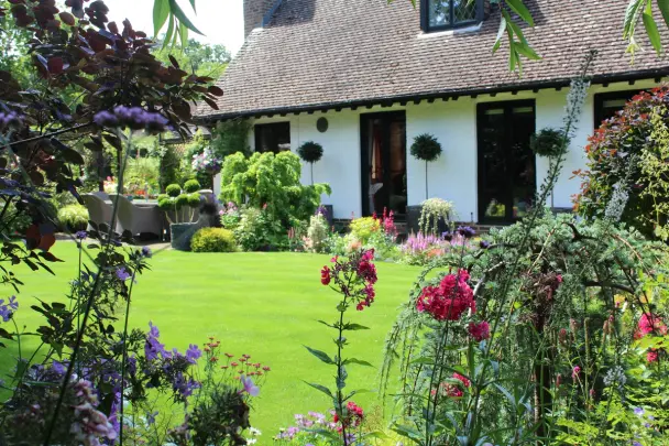 Gardener preparing a lawn for spring in the background on a bright, sunny day.