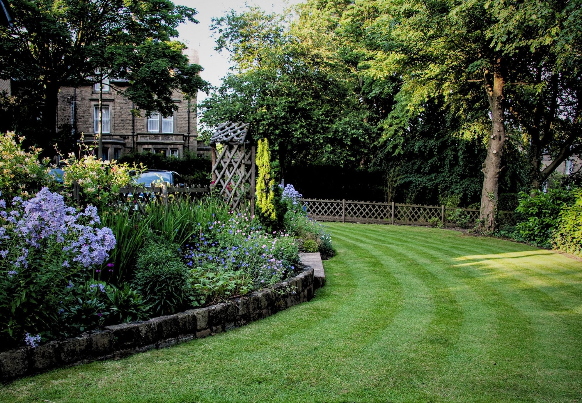 A neatly mown garden lawn with flower borders used as the banner image for the My.GreenThumb Activation page.