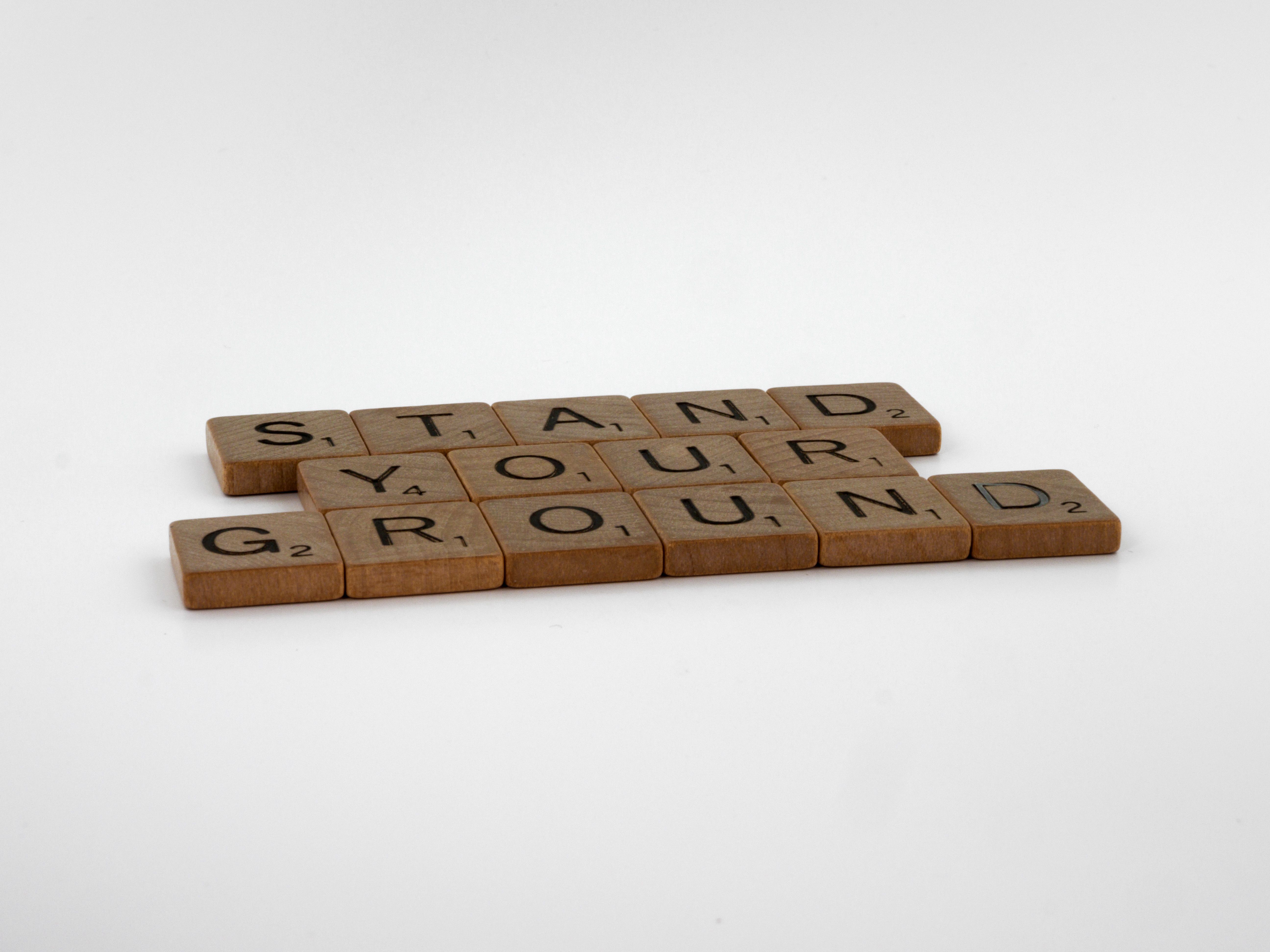 Wooden Scrabble tiles spelling Stand Your Ground, representing Florida's self-defense and use-of-force law