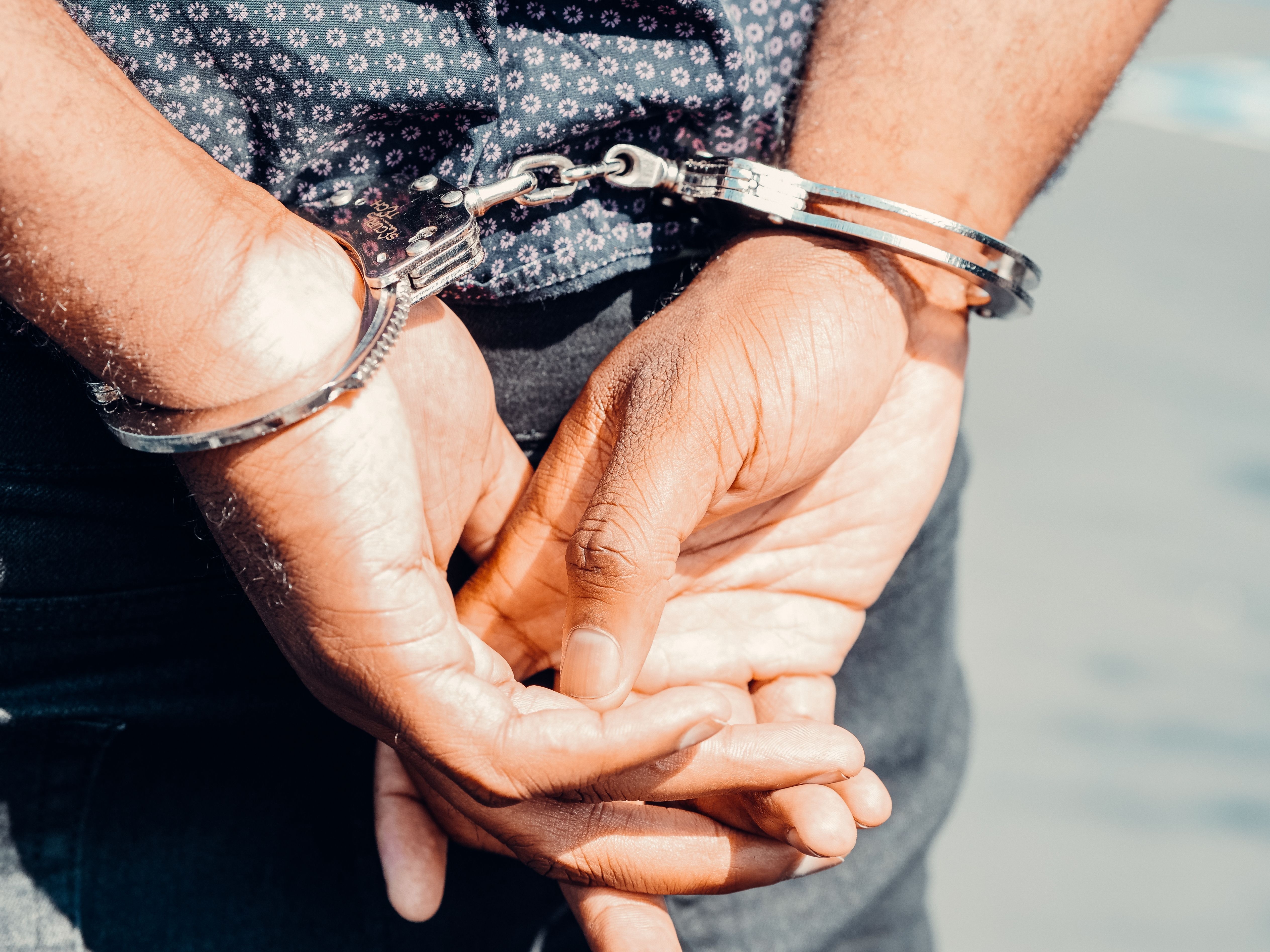 Image Person handcuffed after being arrested in Boynton Beach, awaiting booking with a criminal defense lawyer