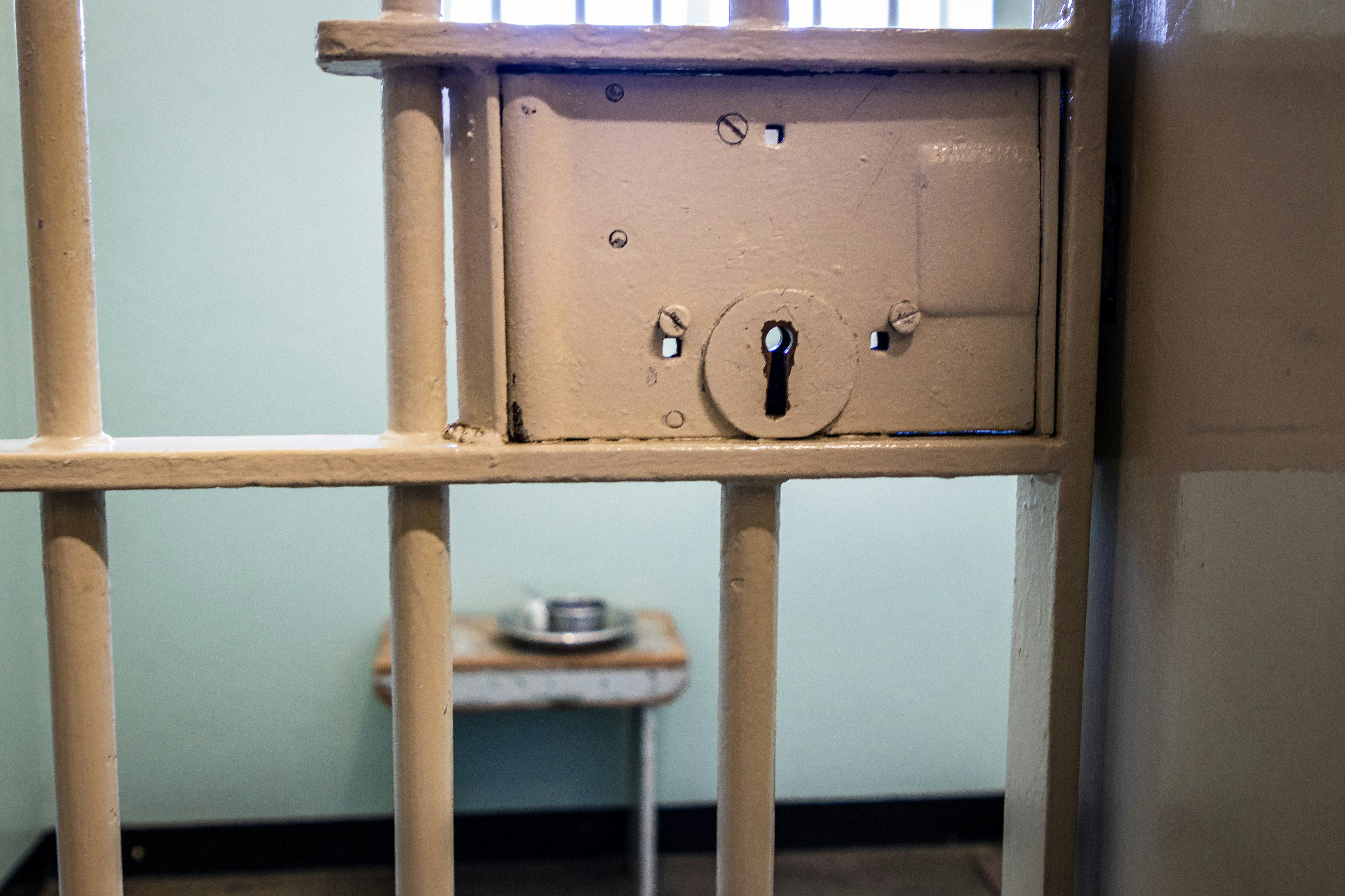 Locked jail cell door with bars and keyhole, illustrating the hold after an arrest, Wellington domestic violence lawyer.