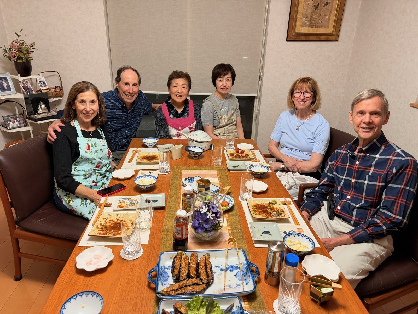 Travelers and hosts seated together around a dining table after a home-cooked meal.