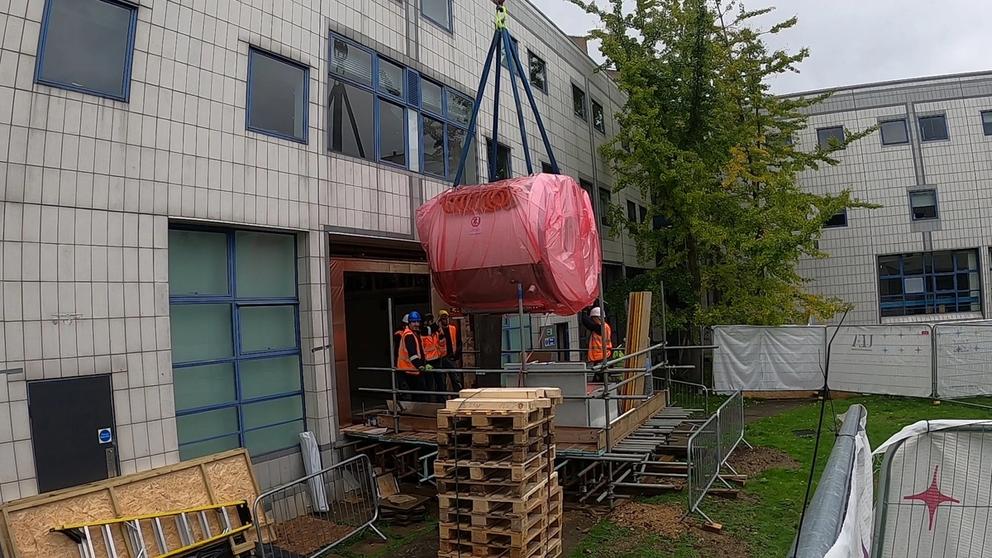 Cluse up of the scanner being lifted into the building by a crane