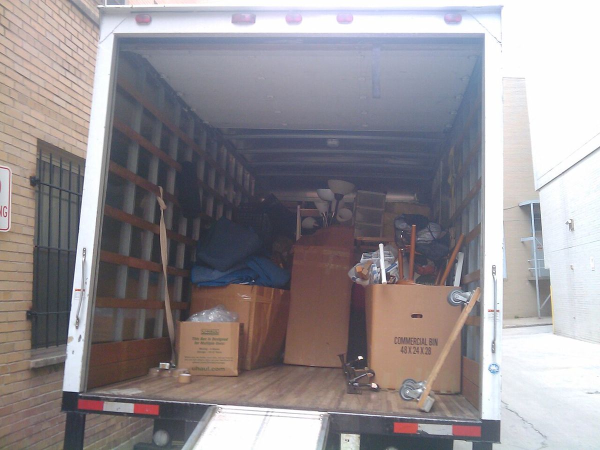 Moving truck loaded with cardboard boxes, a lamp and small furniture