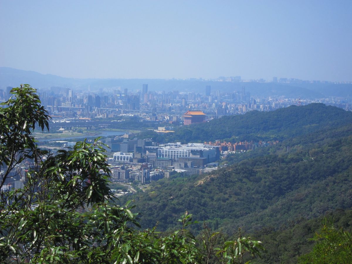 View over Dazhi from the hills, with the red-roofed Grand Hotel, the Keelung River and Taipei's skyline beyond