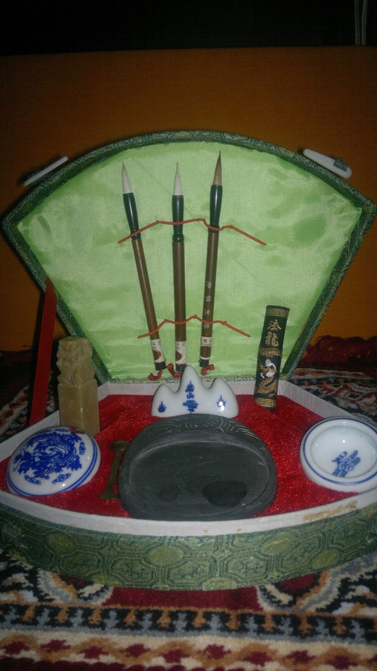 Chinese calligraphy brushes, ink and paper laid out on a table