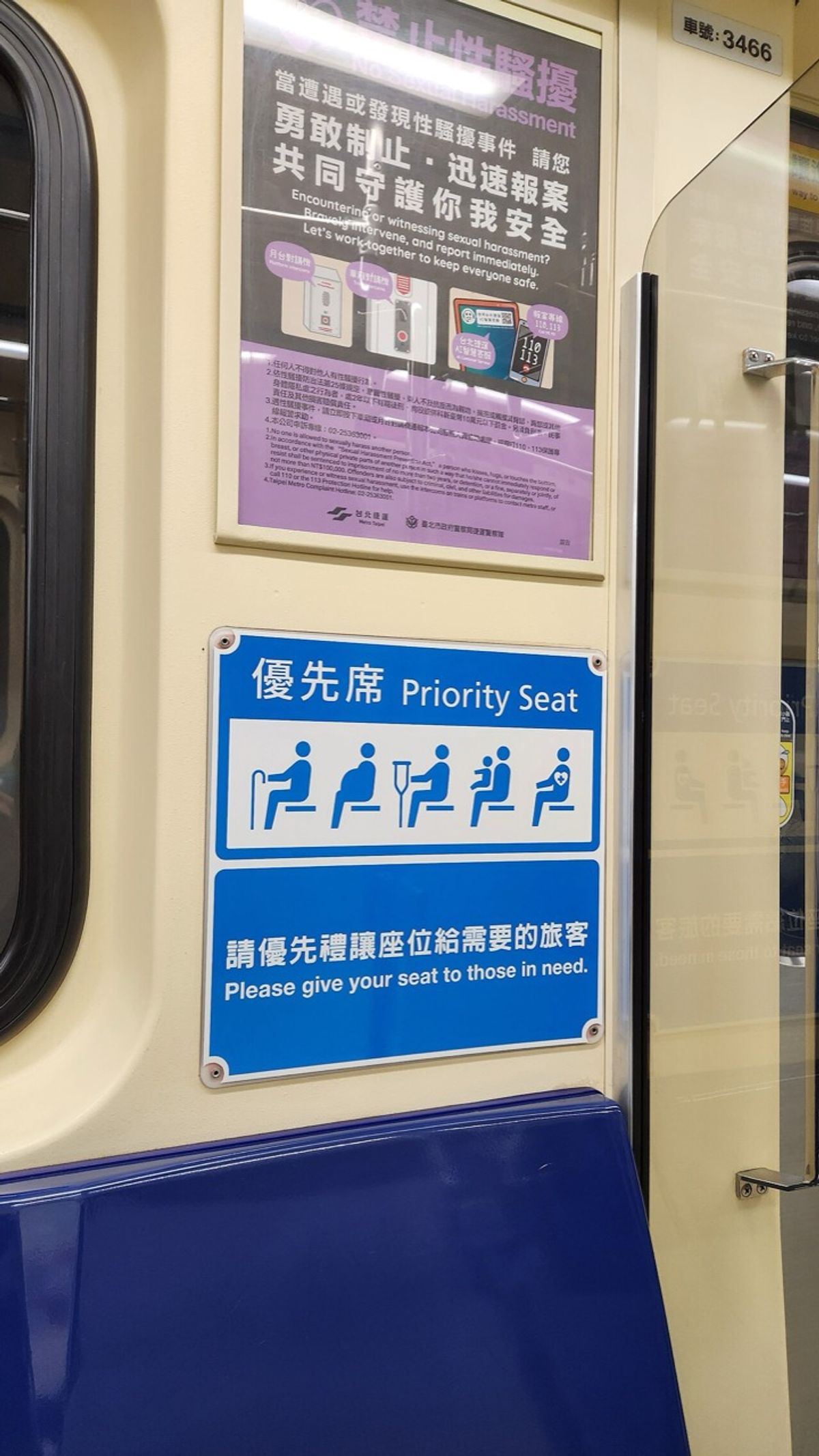 Blue Taipei Metro sign reading Priority Seat in Chinese and English above a dark blue seat