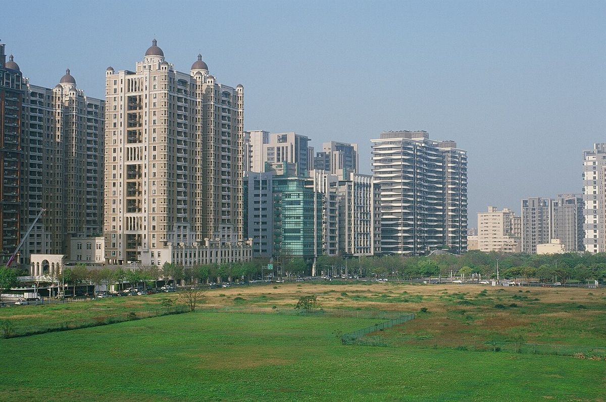 High-rise residential towers in Zhubei, Hsinchu County, behind an open green field