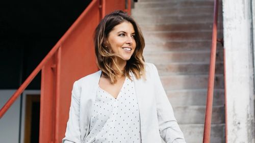Image of Gianna standing in front of a staircase