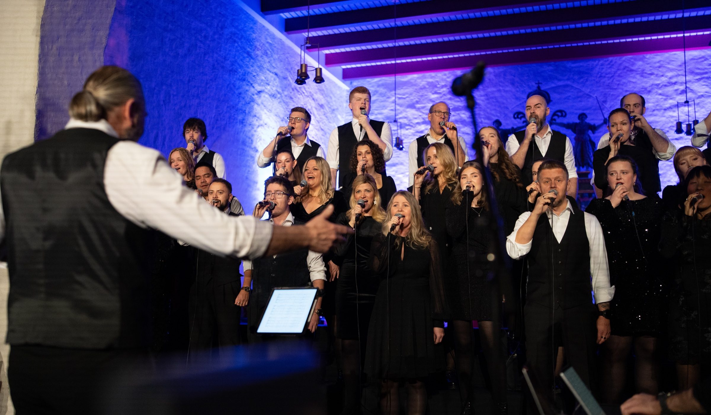 Dirigenten leder The Real Choir under en konsert