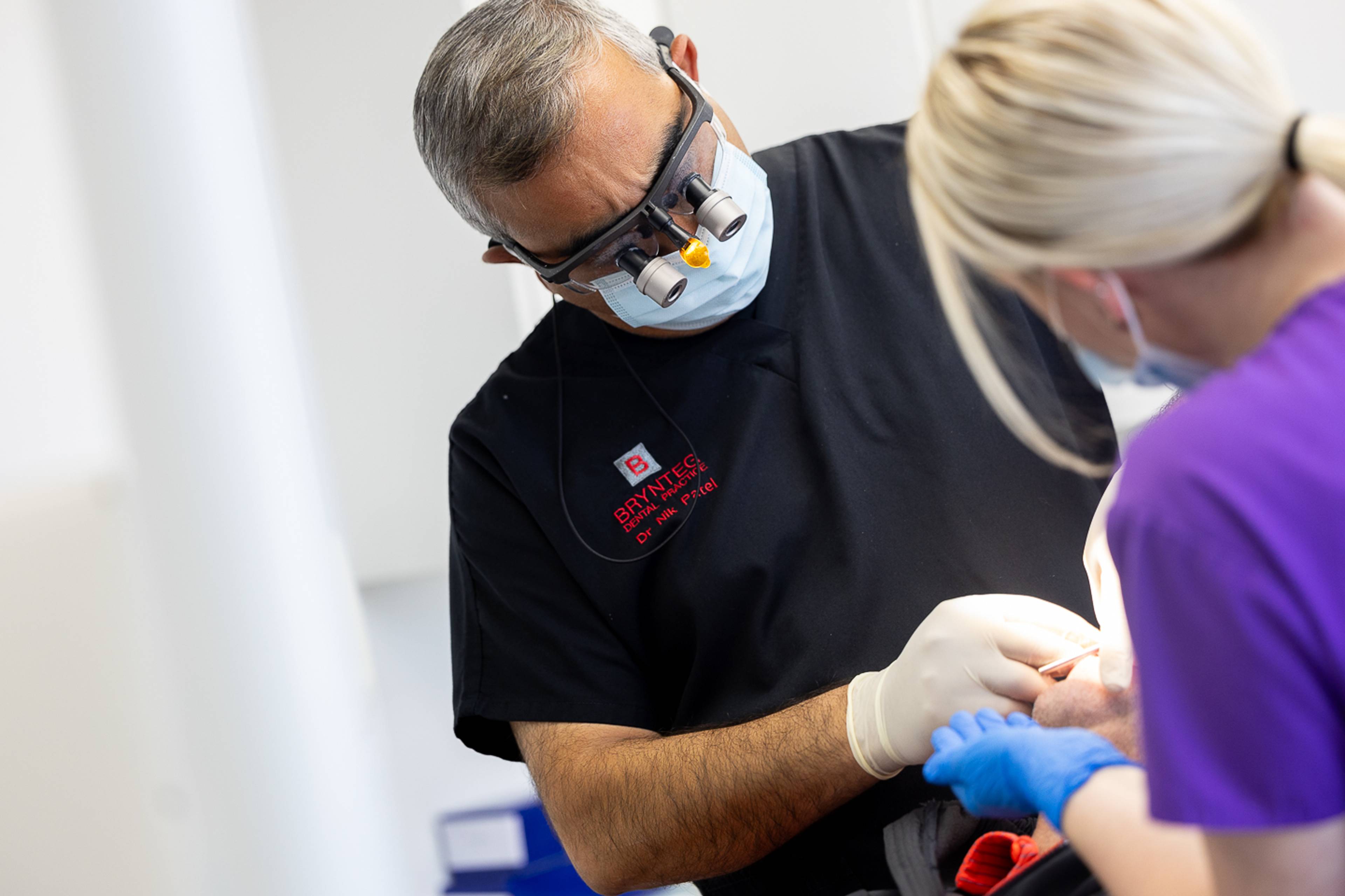 Deintydd yn perfformio triniaeth impio esgyrn