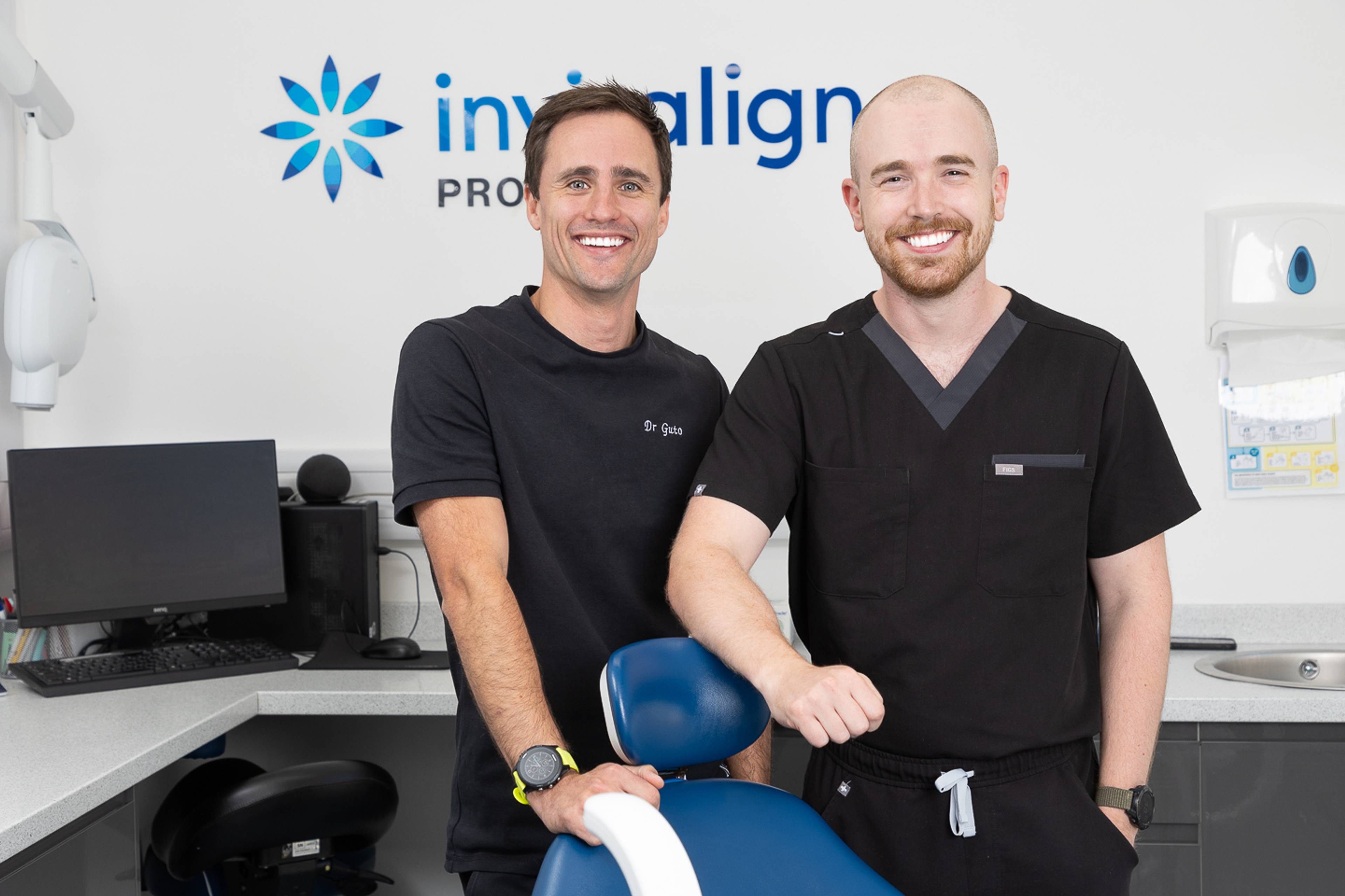 Two dentists smiling in a modern dental surgery