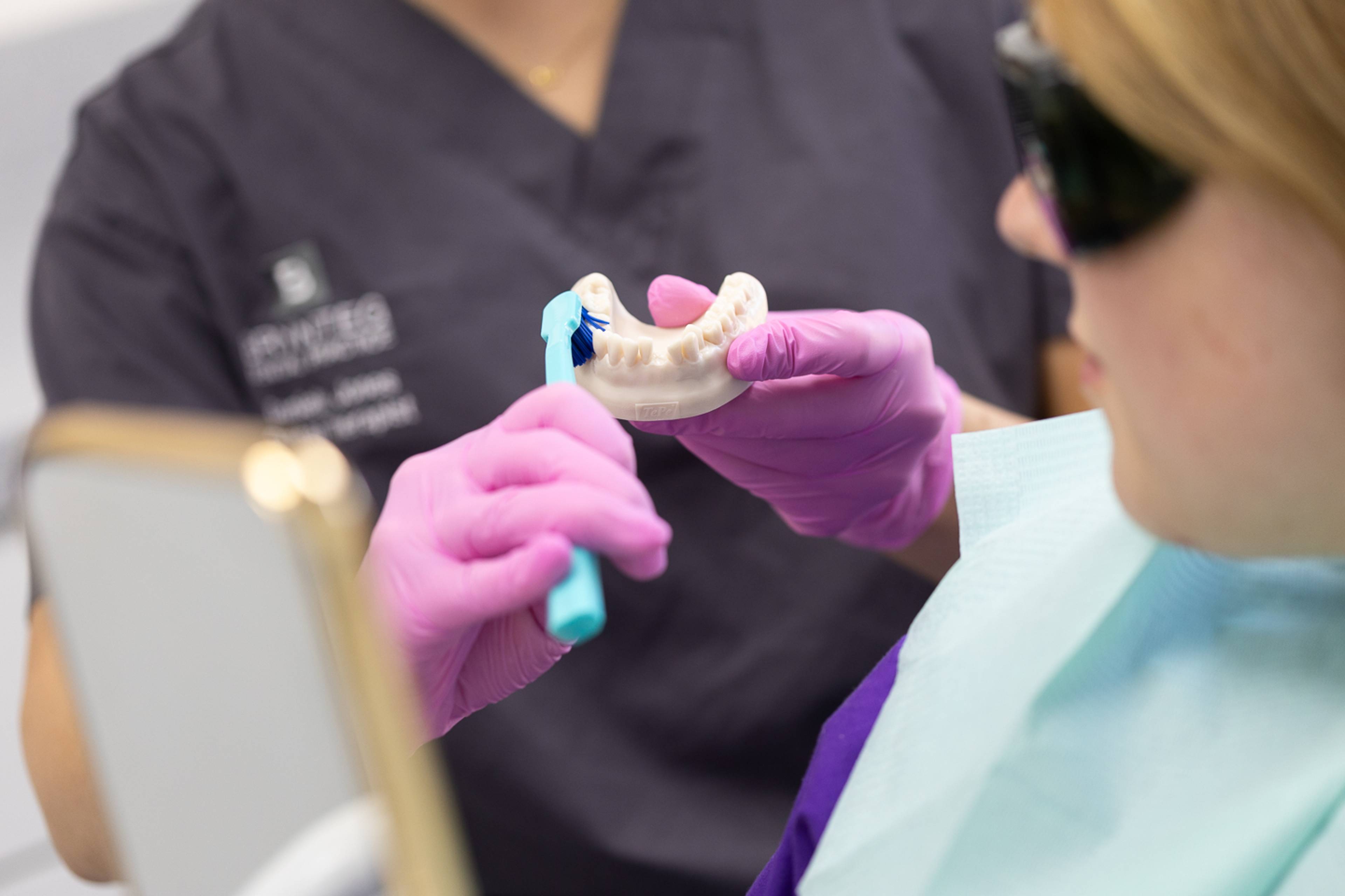 Deintydd yn egluro techneg glanhau