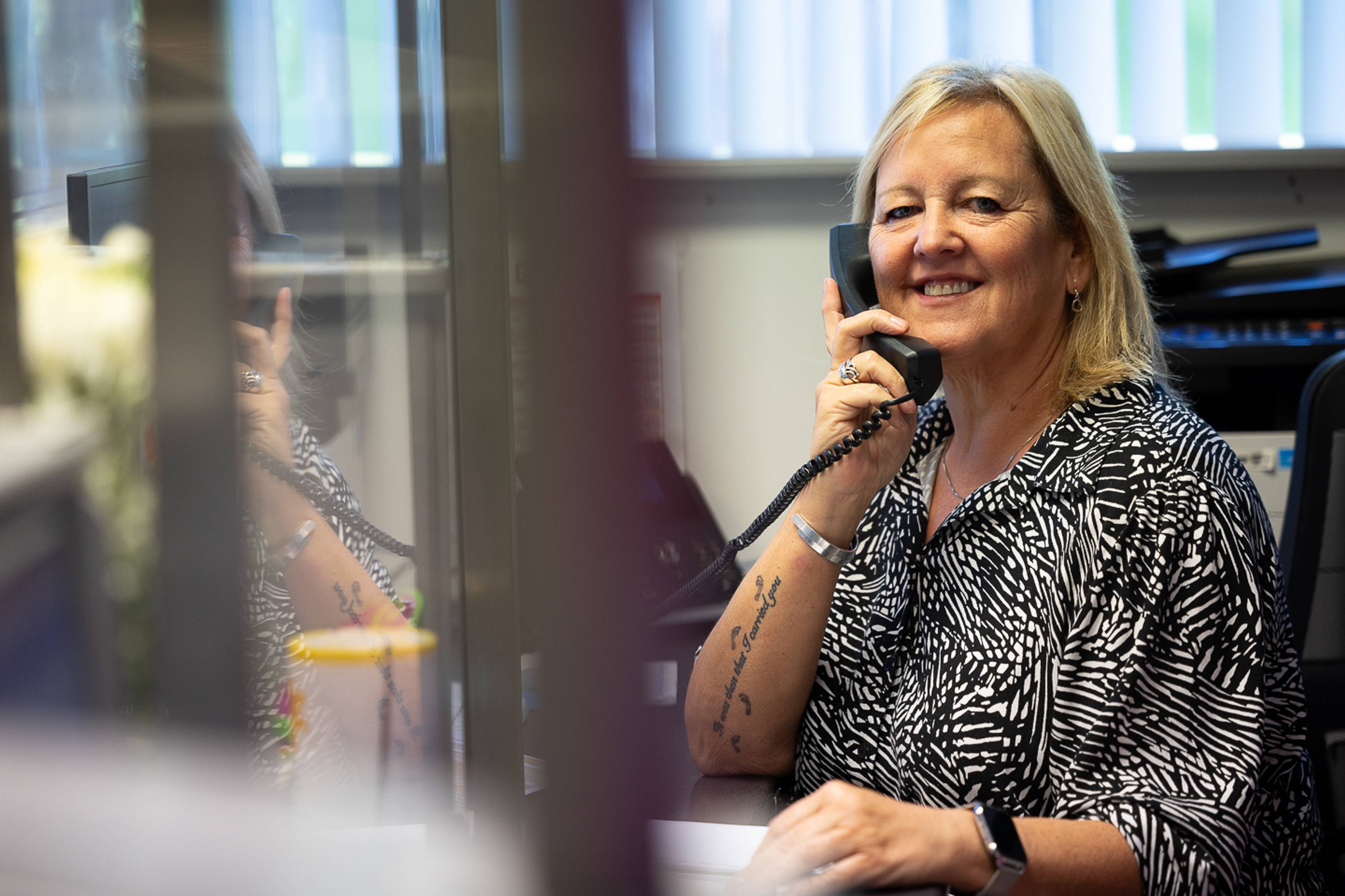 Derbynnydd cyfeillgar yn siarad â chlaf