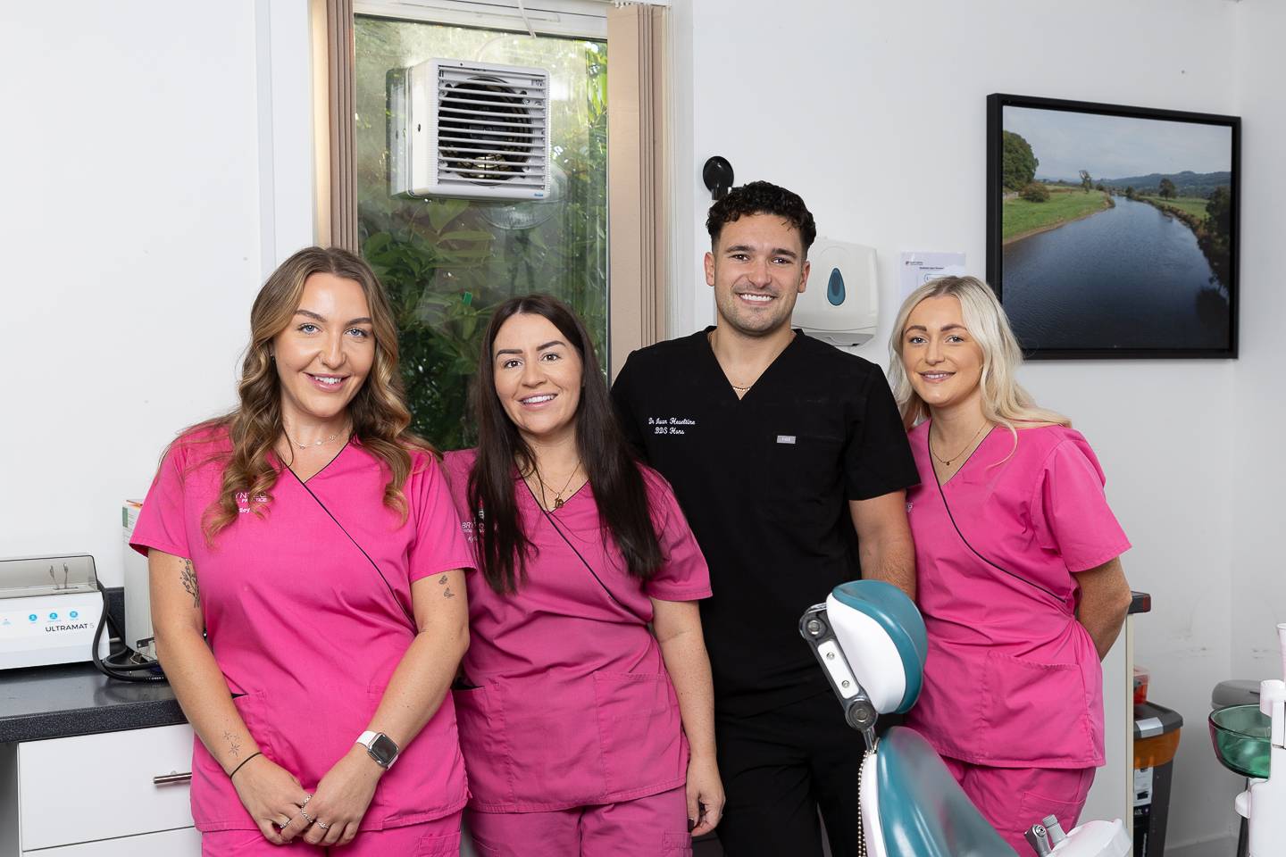 3 nyrs a deintydd yn gwenu mewn llawdriniaeth fodern, ddisglair