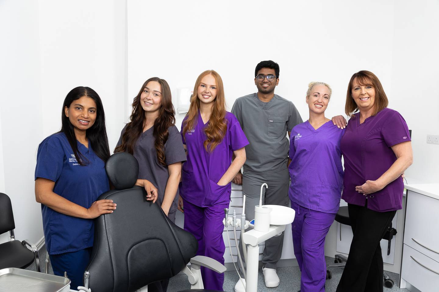 Brynteg Dental Swansea team smiling, standing together in a bright and modern surgery