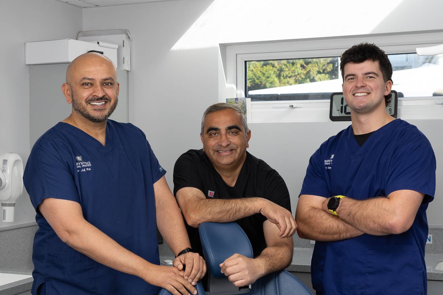 Safodd tri deintydd gyda'i gilydd mewn llawdriniaeth wyn a llwyd yn gwenu ar y camera