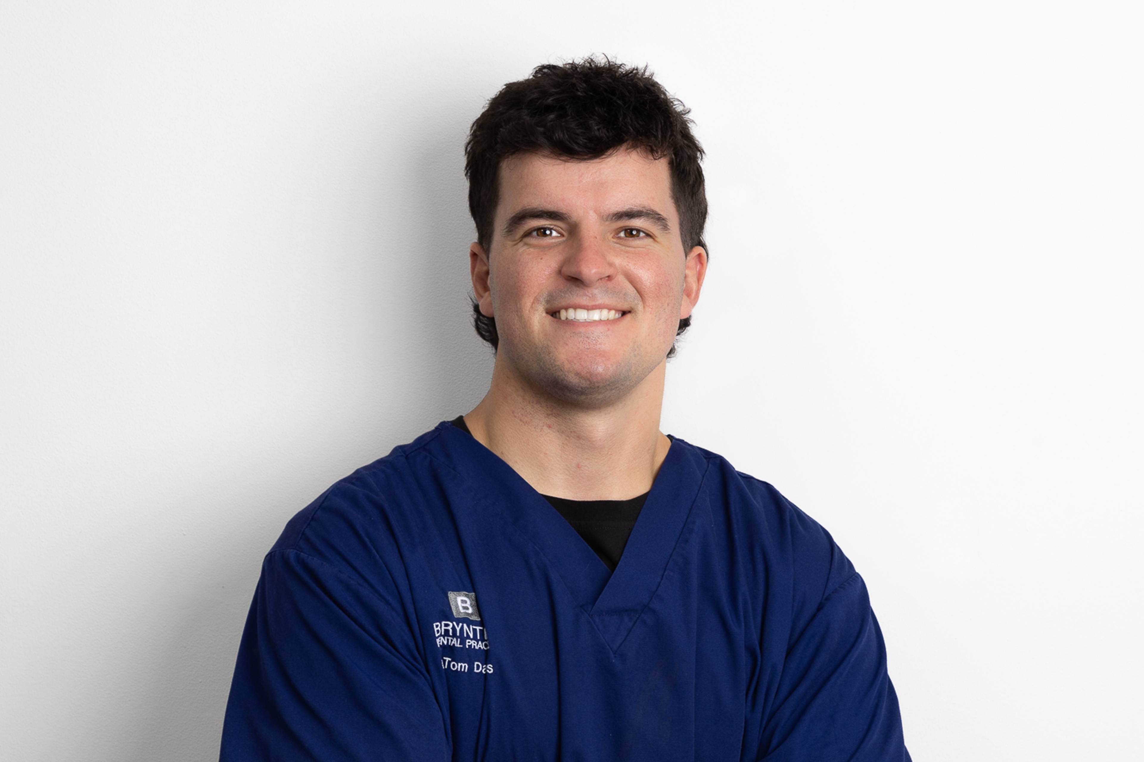 Deintydd Tom Davies yn gwenu ei ben