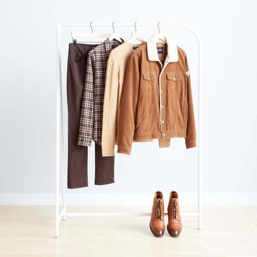 Outfit en colores marrones para temporada de otoño sobre un rack de ropa