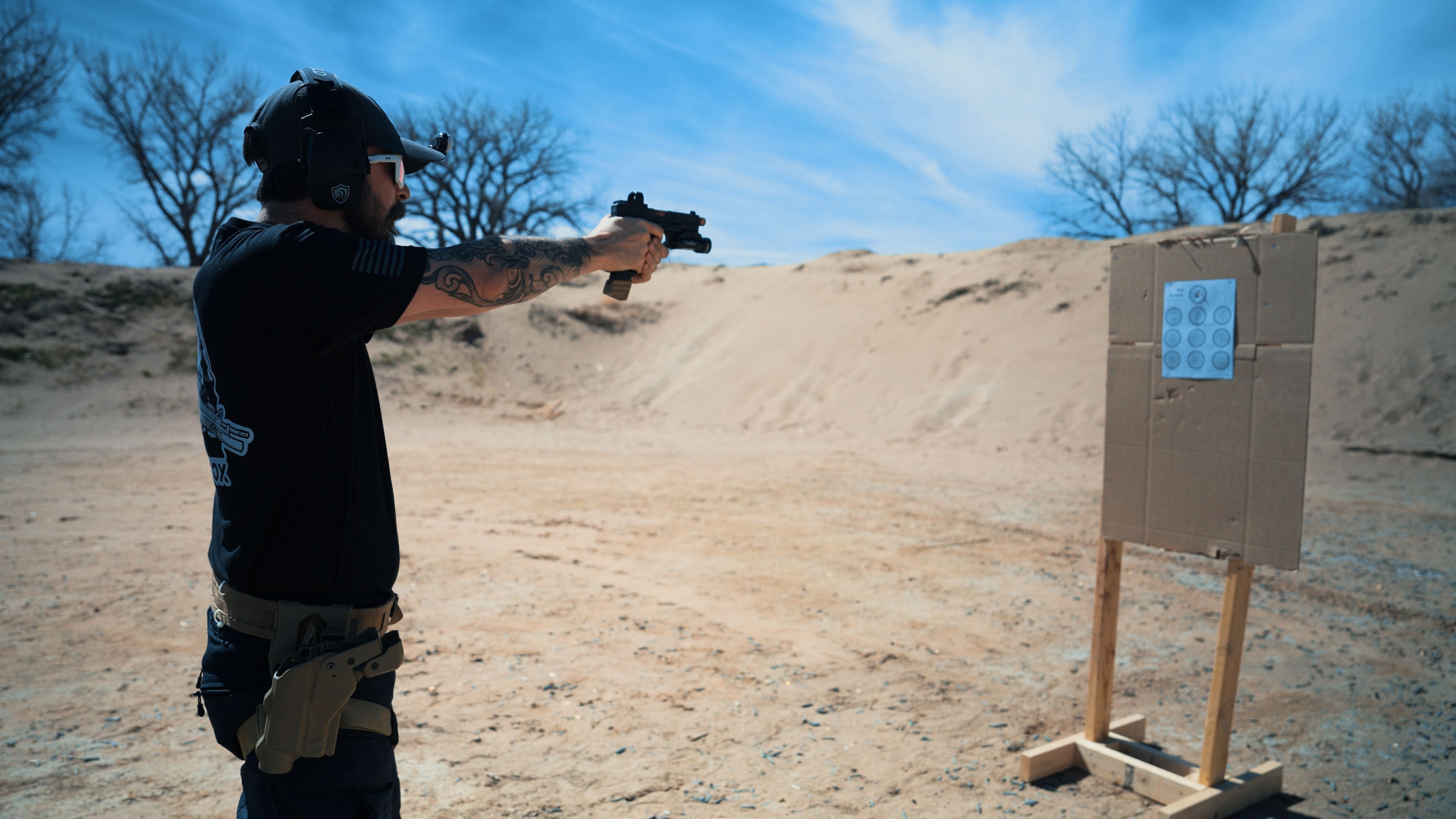 Wide shot of a 20-yard range lane with shooter at the line and target visible downrange