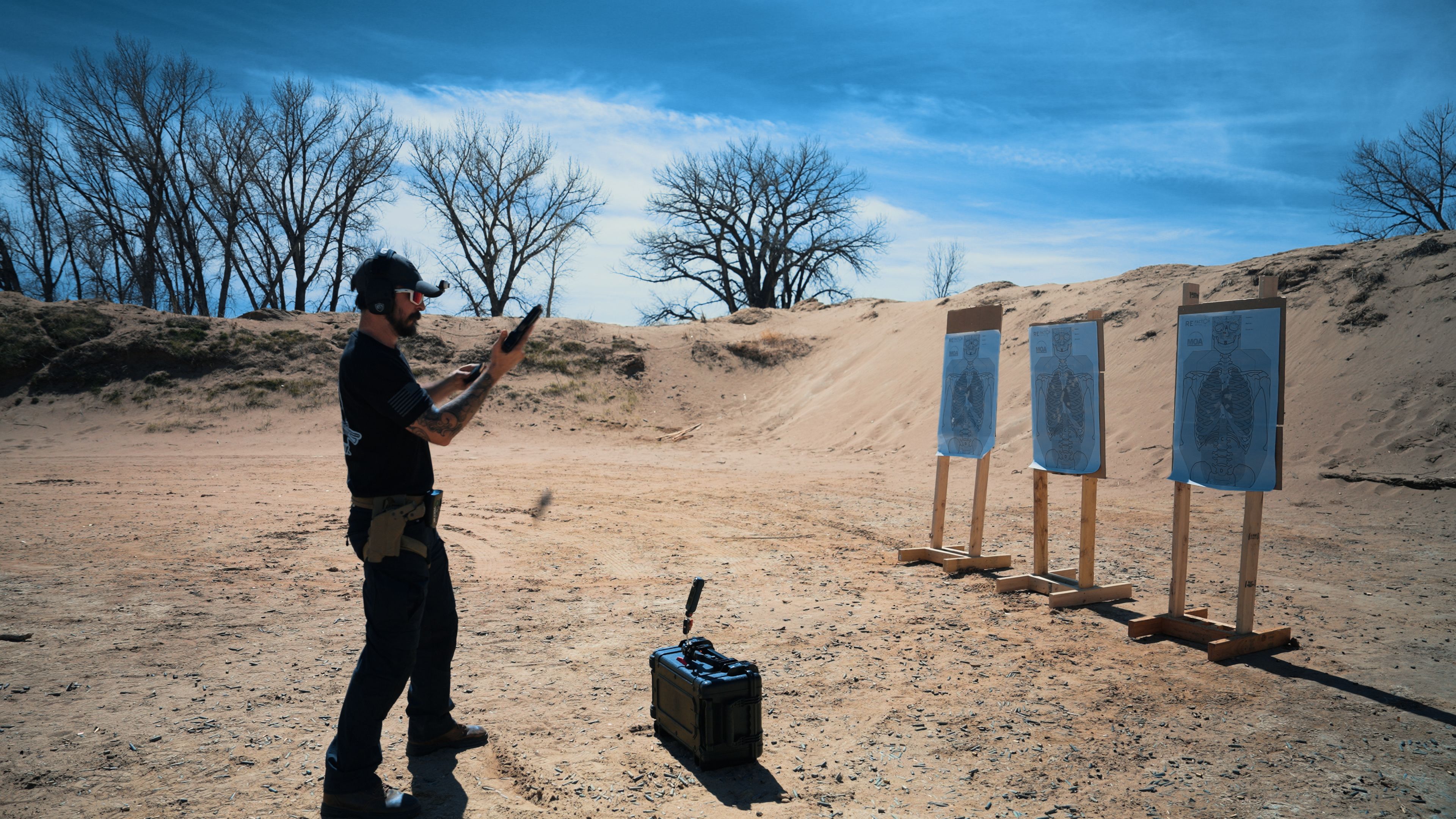 Shooter at the range, pistol extended downrange