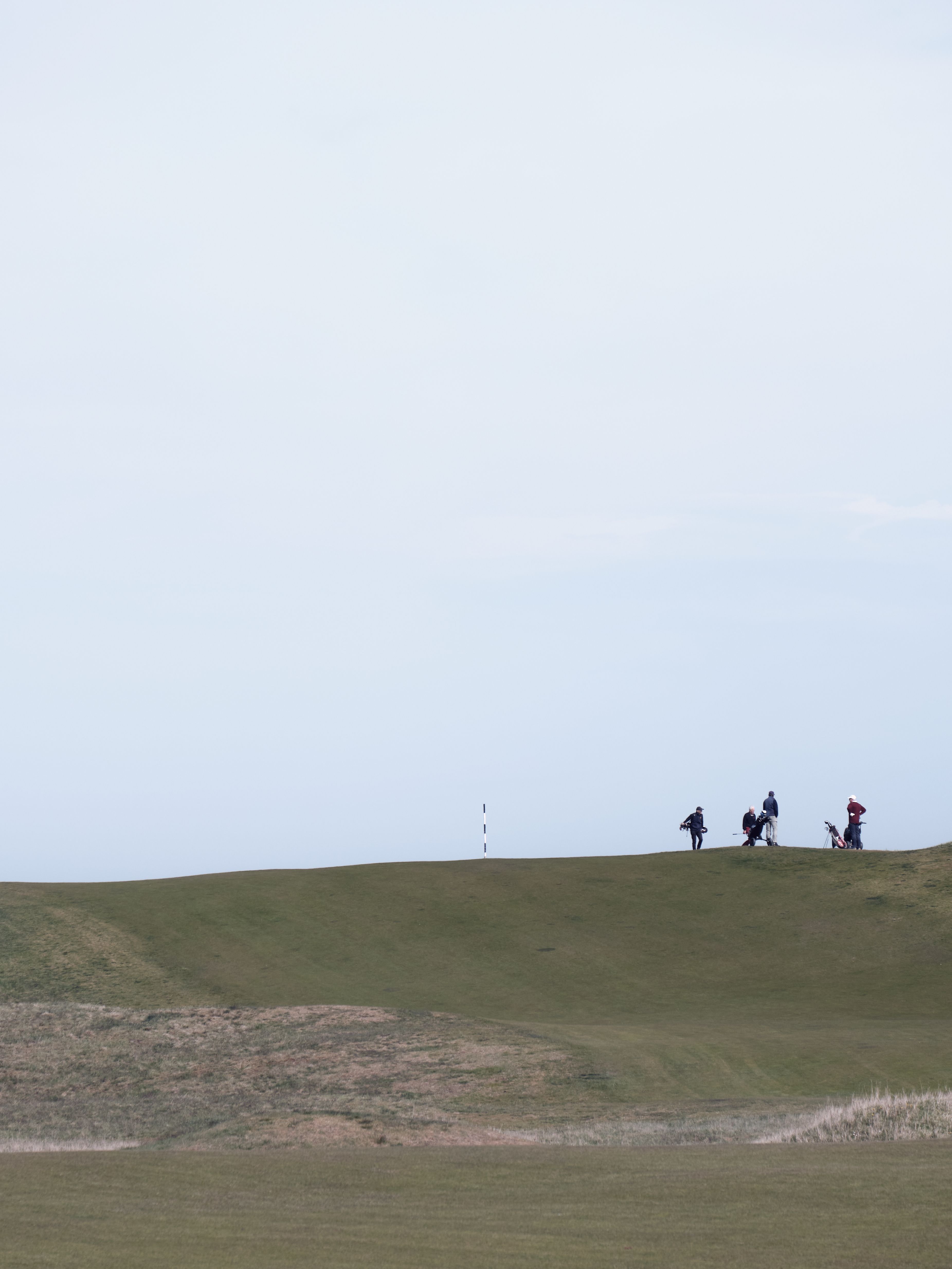 Golfers on a hill walking off