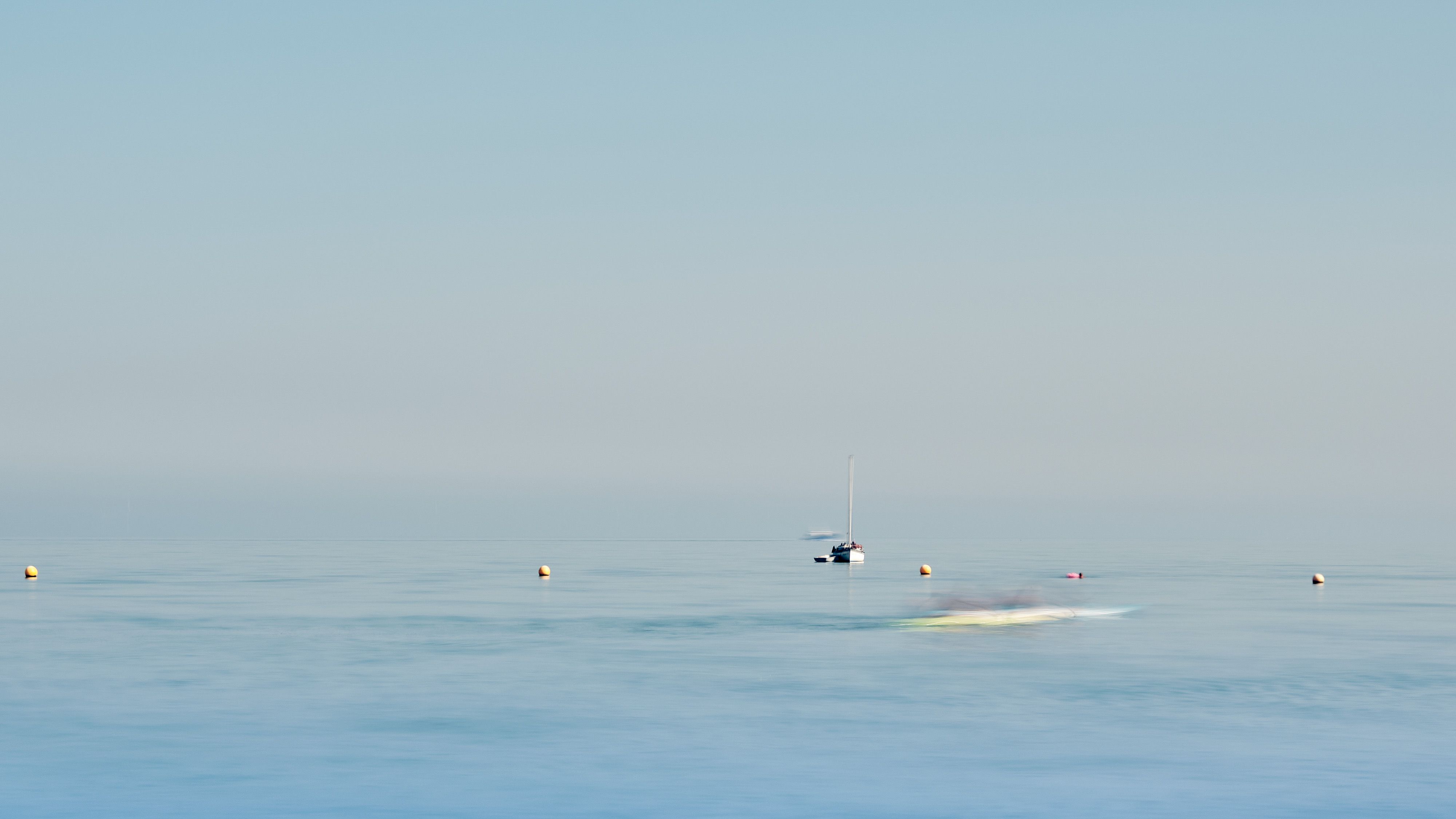 A speed boat flies past making the fishing boat look still